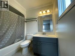 Bathroom featuring vanity, shower / tub combo, ornamental molding, and light tile patterned floors - 
