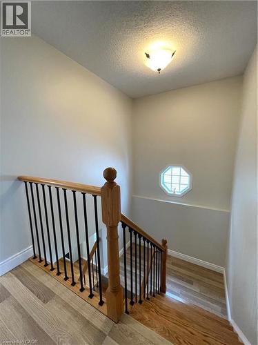 Stairs with a textured ceiling and wood finished floors - 443 Lausanne Crescent, Waterloo, ON - Indoor Photo Showing Other Room