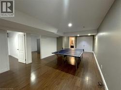 Game room featuring baseboards and dark wood finished floors - 