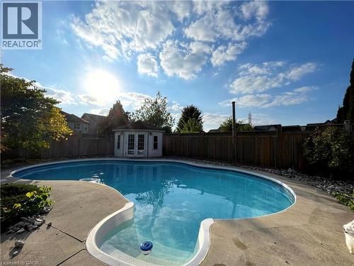 View of pool with a fenced backyard, an outdoor structure, french doors, a patio, and an exterior structure - 443 Lausanne Crescent, Waterloo, ON - Outdoor With In Ground Pool With Backyard