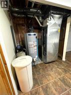 Utility room featuring gas water heater and heating unit - 