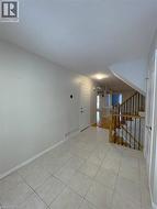 Unfurnished room with stairway, a textured ceiling, and light tile patterned flooring - 