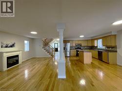 Kitchen featuring a glass covered fireplace, decorative columns, open floor plan, stainless steel fridge with ice dispenser, and range with electric cooktop - 