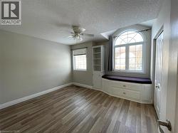 Unfurnished room with a textured ceiling, light wood-style flooring, and ceiling fan - 