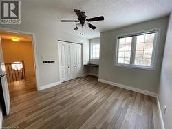 Unfurnished bedroom with light wood finished floors, a textured ceiling, ceiling fan, and a closet - 