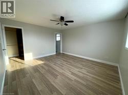 Unfurnished bedroom with light wood-style floors, a ceiling fan, and a textured ceiling - 