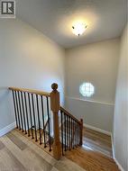 Stairs with a textured ceiling and wood finished floors - 