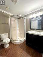 Bathroom with vanity, dark wood finished floors, a stall shower, and crown molding - 