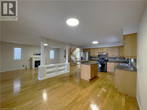 Kitchen featuring open floor plan, a center island, stainless steel appliances, a fireplace, and backsplash - 443 Lausanne Crescent, Waterloo, ON - Indoor Photo Showing Kitchen