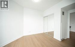 Unfurnished bedroom with wood finished floors and a closet - 