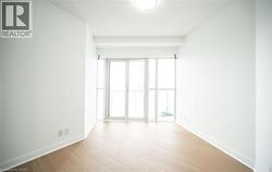 Spare room featuring light wood-style flooring and baseboards - 