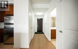 Hallway featuring light wood-style flooring and baseboards - 
