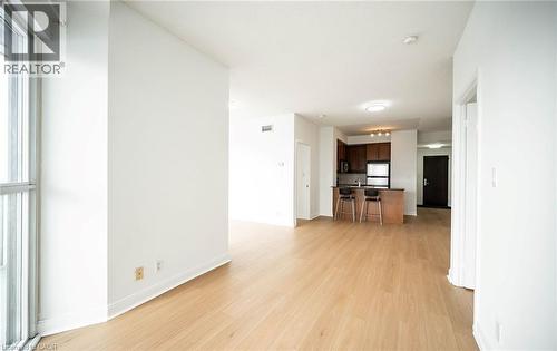 Unfurnished living room with light wood-style floors and baseboards - 50 Absolute Avenue Unit# 2105, Mississauga, ON - Indoor