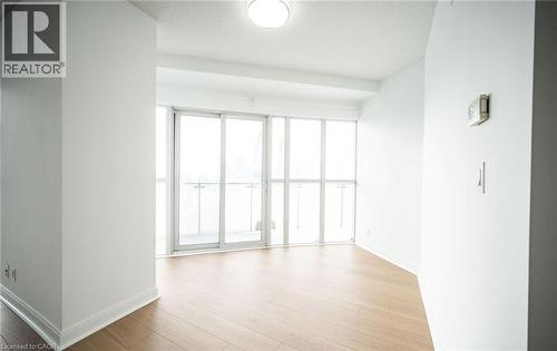 Unfurnished room featuring light wood-type flooring and a textured ceiling - 50 Absolute Avenue Unit# 2105, Mississauga, ON - Indoor Photo Showing Other Room