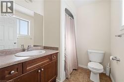 Full bath with a shower with curtain, vanity, and plenty of natural light - 