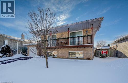 Snow covered rear of property featuring a balcony and brick siding - 42 Ruffian Road, Brantford, ON - Outdoor With Balcony