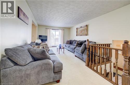Living room featuring a textured ceiling and carpet flooring - 42 Ruffian Road, Brantford, ON - Indoor Photo Showing Living Room