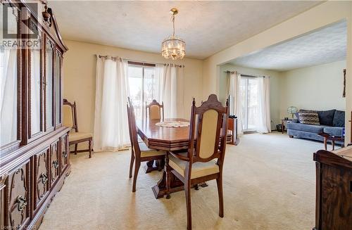 Dining area with light carpet, a chandelier, and a textured ceiling - 42 Ruffian Road, Brantford, ON - Indoor Photo Showing Dining Room