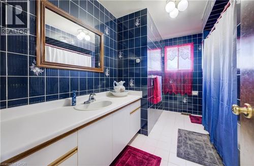 Full bath with vanity, light tile patterned floors, tile walls, and curtained shower - 42 Ruffian Road, Brantford, ON - Indoor Photo Showing Bathroom