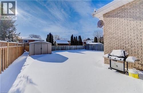 Yard covered in snow featuring a storage shed and a fenced backyard - 42 Ruffian Road, Brantford, ON - Outdoor
