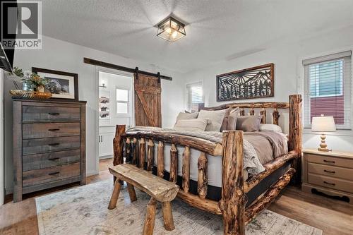 Master bedroom with walk in closet - 311 Mcleod Crescent, Diamond Valley, AB - Indoor Photo Showing Bedroom