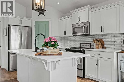 Updated lighting throughout - 311 Mcleod Crescent, Diamond Valley, AB - Indoor Photo Showing Kitchen With Upgraded Kitchen