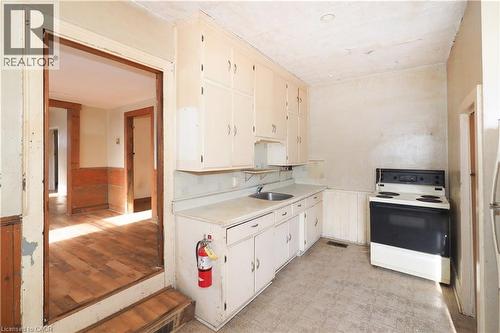 Kitchen featuring white electric stove, light countertops, light flooring, wainscoting, and cream cabinetry - 37 Northumberland Street, Ayr, ON - Indoor Photo Showing Kitchen