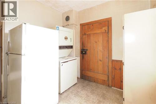 Laundry room with light floors, wooden walls, a wainscoted wall, and stacked washer / drying machine - 37 Northumberland Street, Ayr, ON - Indoor Photo Showing Laundry Room