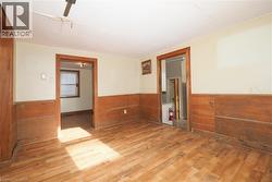 Empty room with wood finished floors, wooden walls, and wainscoting - 