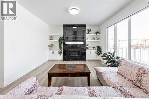 Large Windows - 27 Bridges Drive, Langdon, AB - Indoor Photo Showing Living Room With Fireplace