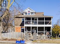 View of front facade featuring covered porch and a shingled roof - 