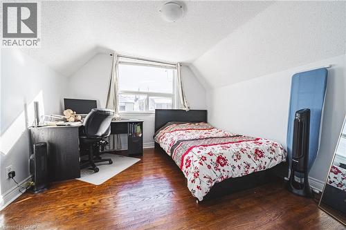 Bedroom featuring a textured ceiling, dark wood-type flooring, lofted ceiling, and an office area - 143 Fairfield Avenue, Hamilton, ON - Indoor
