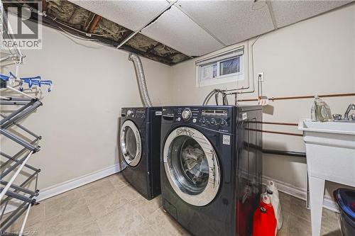Laundry area with washing machine and clothes dryer, a drop ceiling, and tile patterned flooring - 143 Fairfield Avenue, Hamilton, ON - Indoor Photo Showing Laundry Room
