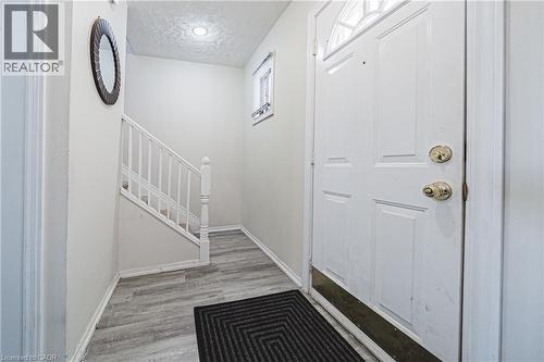 Foyer entrance featuring a textured ceiling, light wood-style floors, and stairway - 143 Fairfield Avenue, Hamilton, ON - Indoor Photo Showing Other Room