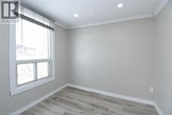Spare room with light wood finished floors, crown molding, and recessed lighting - 