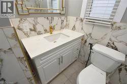Bathroom featuring vanity, a wainscoted wall, and tile walls - 