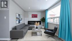 Living area with a premium fireplace, wood finished floors, and recessed lighting - 