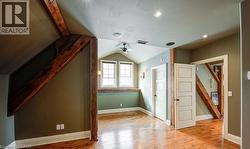 Bonus room with light wood finished floors and a ceiling fan - 