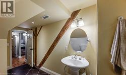 Half bath featuring dark tile patterned floors and baseboards - 