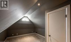Additional living space featuring lofted ceiling and light carpet - 