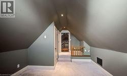 Additional living space featuring light carpet and lofted ceiling - 