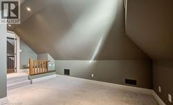 Bonus room with lofted ceiling, light carpet, and recessed lighting - 