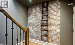 Stairs featuring wood finished floors and brick wall - 