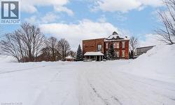Snow covered property with brick siding - 