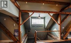Stairway featuring beam ceiling and a ceiling fan - 