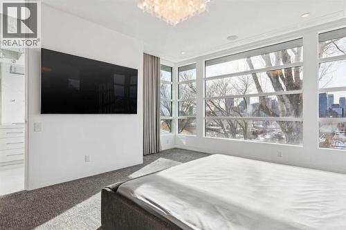 CORNER WINDOWS EXTEND THE VIEWS. WALL-MOUNTED TV - 530 Crescent Road Nw, Calgary, AB - Indoor Photo Showing Bedroom