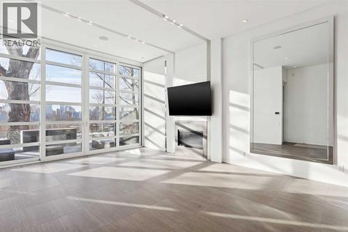 FLOOR TO CEILINGS WINDOWS TO CAPTURE THE VIEWS. GAS FIREPLACE. TV INCLUDED - 530 Crescent Road Nw, Calgary, AB - Indoor Photo Showing Other Room
