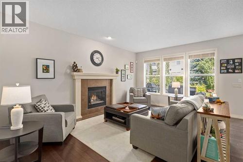 Living - 112 Sunset View, Cochrane, AB - Indoor Photo Showing Living Room With Fireplace