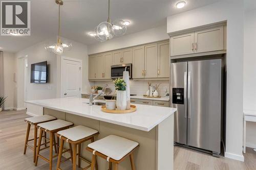 PLEASE NOTE: Photos are of a finished Showhome of the same model – fit and finish may differ on finished spec home. Interior selections and floorplans shown in photos - 62 Starling Boulevard Nw, Calgary, AB - Indoor Photo Showing Kitchen With Upgraded Kitchen