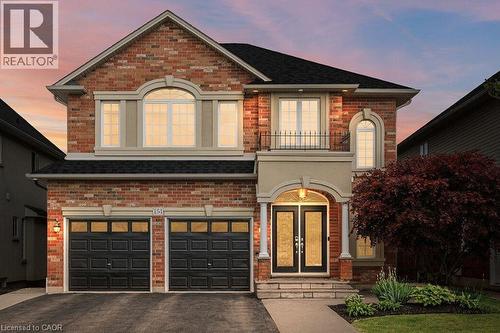 View of front of property with an attached garage, brick siding, and driveway - 151 Fair Street, Ancaster, ON 